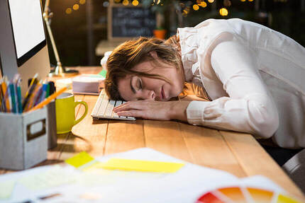 Tired businesswoman sleeping on the desk in the office