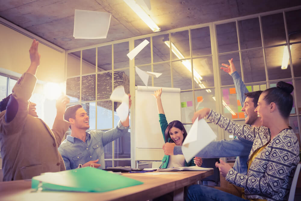 Group of business people celebrating by throwing their business papers in the air