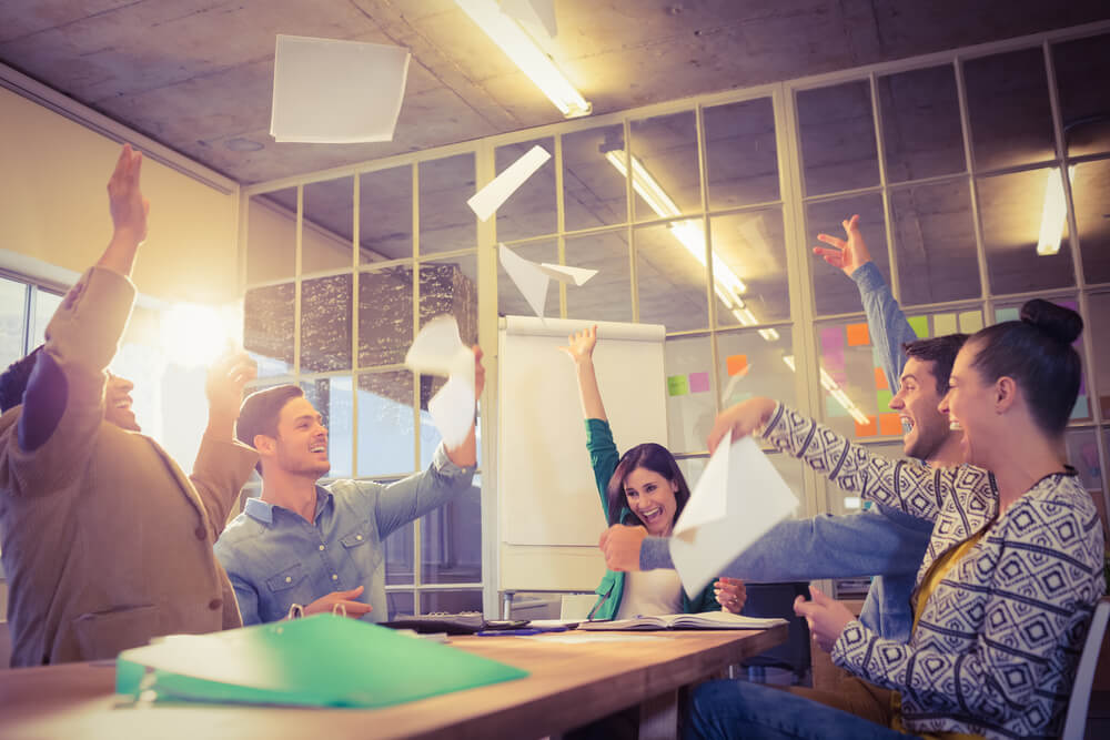 Group of business people celebrating by throwing their business papers in the air Group of business people celebrating by throwing their business papers in the air