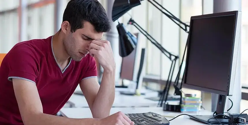 frustrated young business man working on laptop computer at office (2) (1) (1)